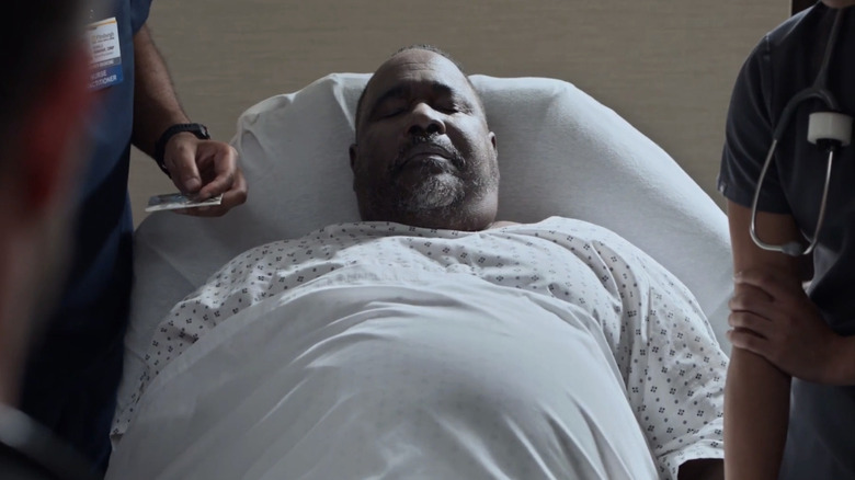 Ernest Harden Jr.'s Louie Cloverfield lays propped up on a stretcher in The Pitt