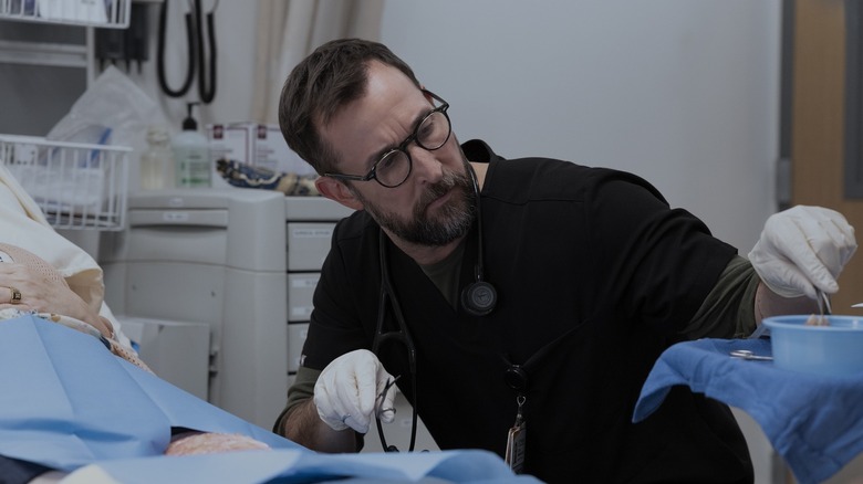 Robby treating Yana's burns wearing glasses on The Pitt