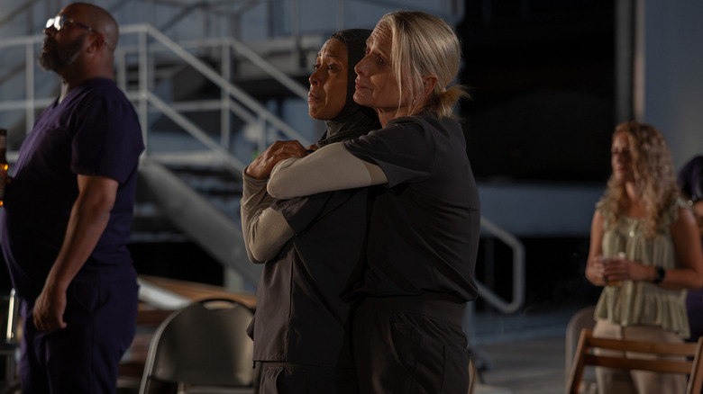 Amielynn Abellera as Nurse Perlah and Katherine LaNasa as Nurse Dana hugging and watching the fireworks on the roof of the hospital on The Pitt