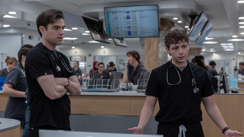 Langdon and Whitaker looking concerned at the charge desk on The Pitt