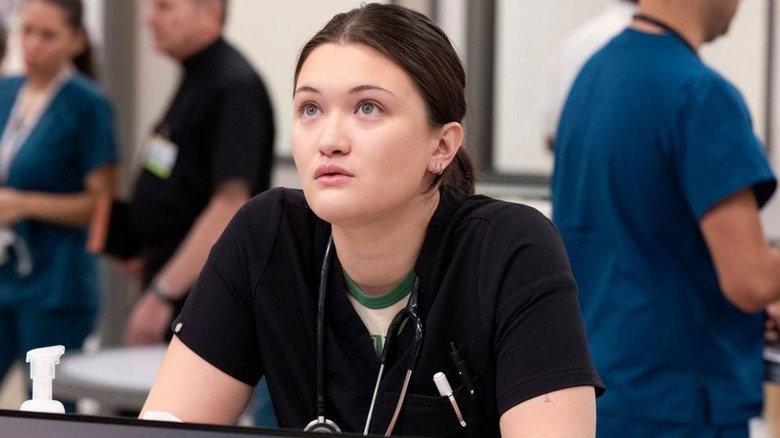 Isa Briones as Dr. Santos looks up at the emergency board in The Pitt