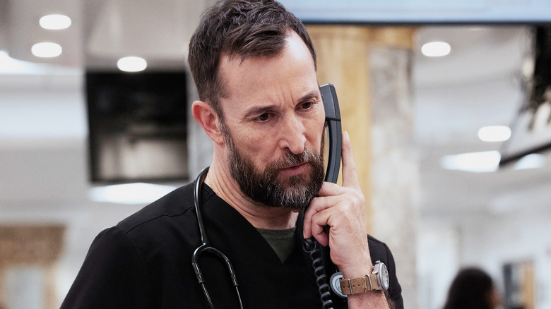 Noah Wyle's Michael Robinavitch talks on the phone in the ER in The Pitt