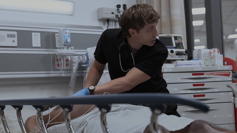 Dr. Whitaker looking over his shoulder and yelling for help as a patient starts dying in The Pitt