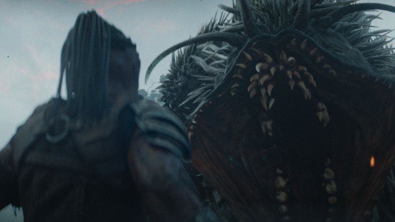 Dek facing down a toothsome beastie in Predator: Badlands