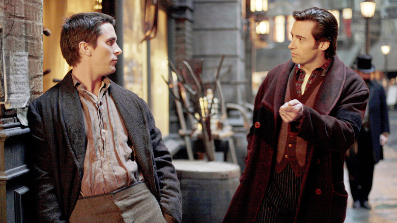 Christian Bale and Hugh Jackman stare confrontationally on the street