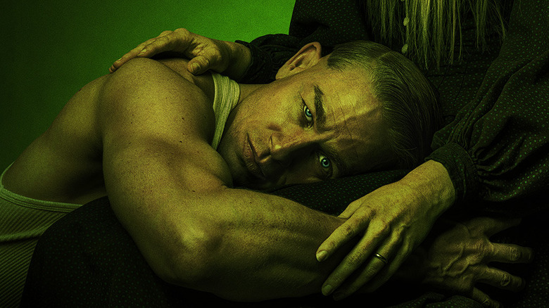 Charlie Hunnam as Ed Gein, laying in the lap of his mother and looking at the camera on the poster for Monster: The Ed Gein Story