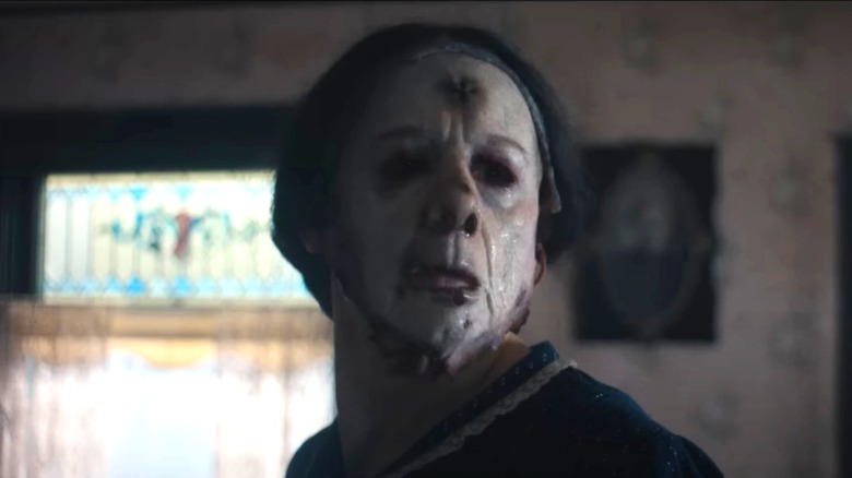 Charlie Hunnam as Ed Gein wearing a dress and a skin mask in Monster: The Ed Gein Story