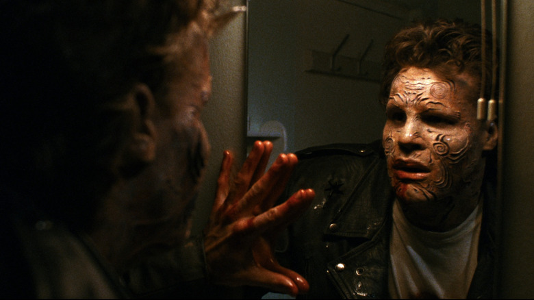 Boone with a bloodied hand staring at his changed reflection in the mirror in Nightbreed