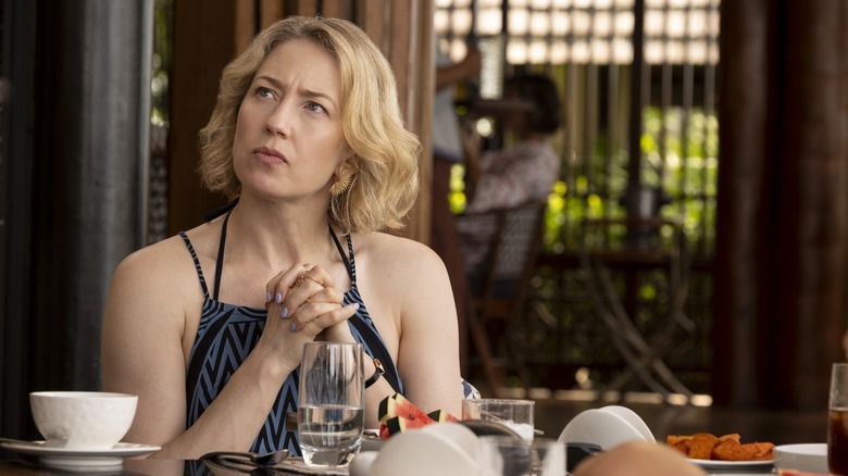 Carrie Coon sebagai Larie Duffy menyatukan tangannya di meja di lotus putih