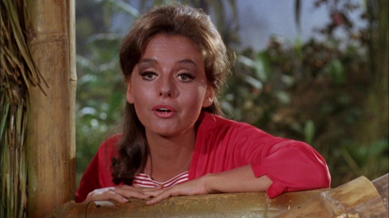 Mary Ann olhando através de uma janela para a ilha de Gilligan.