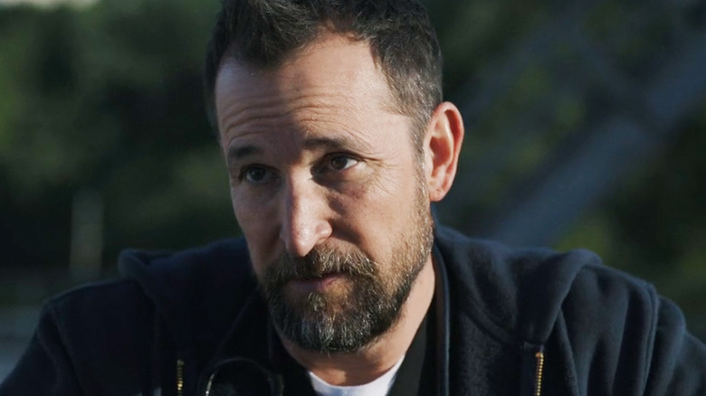 Noah Wyle's Dr Michael Robinavitch looks off to his right in The Pitt