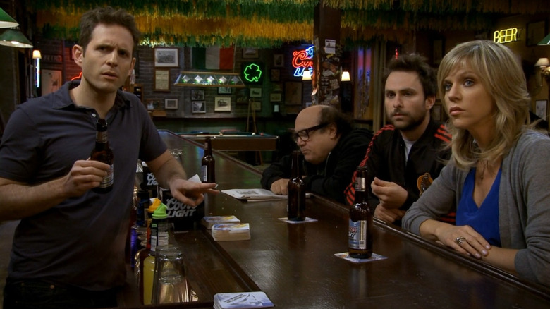 Dennis (Glen Howerton), Frank (Danny DeVito), Charlie (Charlie Day), and Dee (Kaitlin Olson) hanging around the bar in It's Always Sunny in Philadelphia