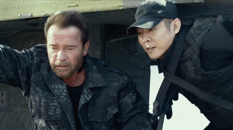 Arnold Schwarzenegger and Jet Li looking out of a chopper in The Expendables 3