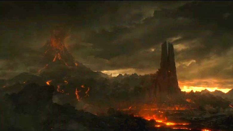 An establishing shot of an erupting volcano next to a black tower made out of stone in The Lord of the Rings: The Rings of Power
