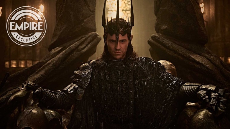 Charlie Vickers as Sauron wearing his crown and seated on a throne in The Lord of the Rings: The Rings of Power
