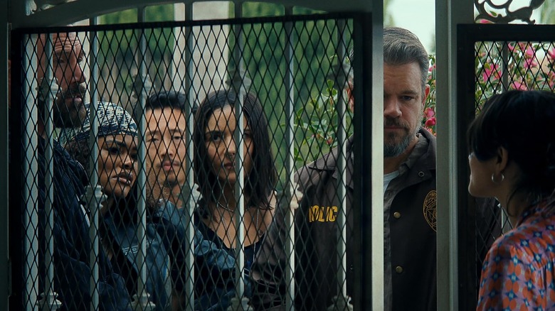 Matt Damon as Dane Dumars speaks to a woman at the gate of her house in The Rip