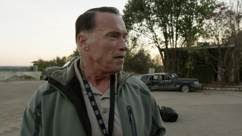 John Wharton van Arnold Schwarzenegger staat buiten en kijkt naar links in Sabotage