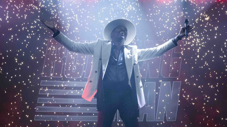 Bobby T stands on stage in The Running Man