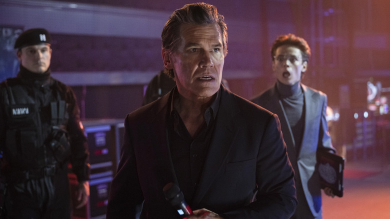 Dan Killian watching a roudy Running Man crowd with concern backstage in The Running Man