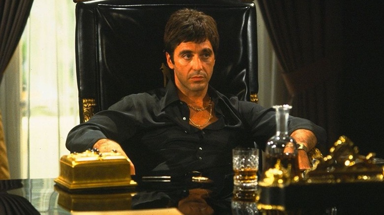 Tony Montana sitting at his desk