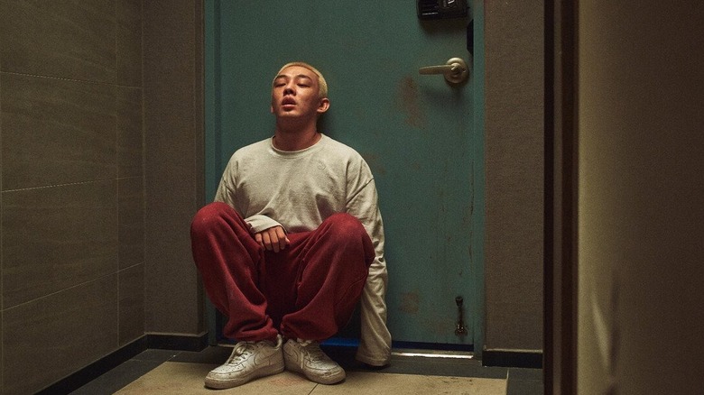 Yoo Ah-in as Oh Joon-woo hides behind door