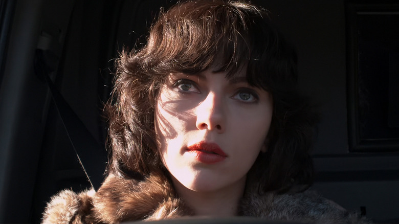 Scarlett Johansson's the Female sits in a van with her face lit by sun in Under the Skin
