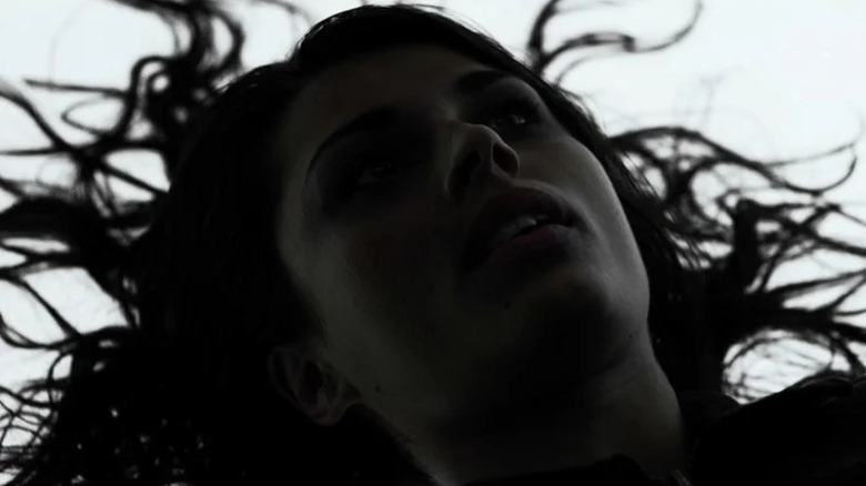 A woman lying on the floor looking up in Under the Skin