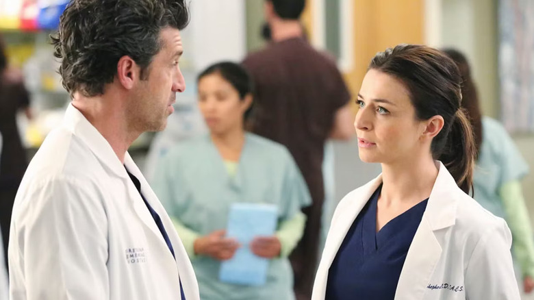 Derek and Amelia talking in the hallway on Grey's Anatomy