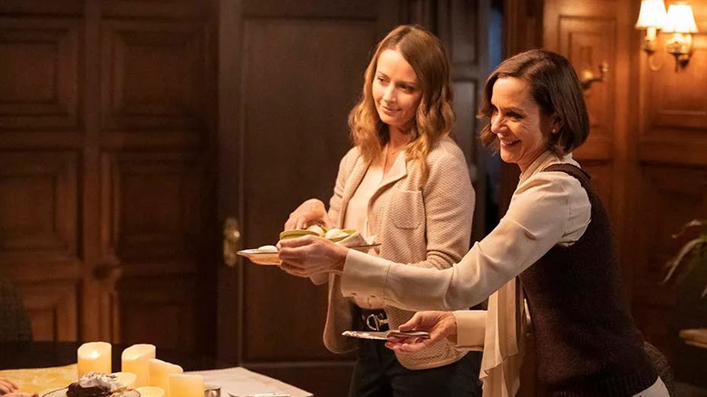 Kathleen and Nancy holding plates near a dinner table on