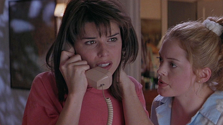 Sidney on the phone with Tatum looking on in Scream (1996)