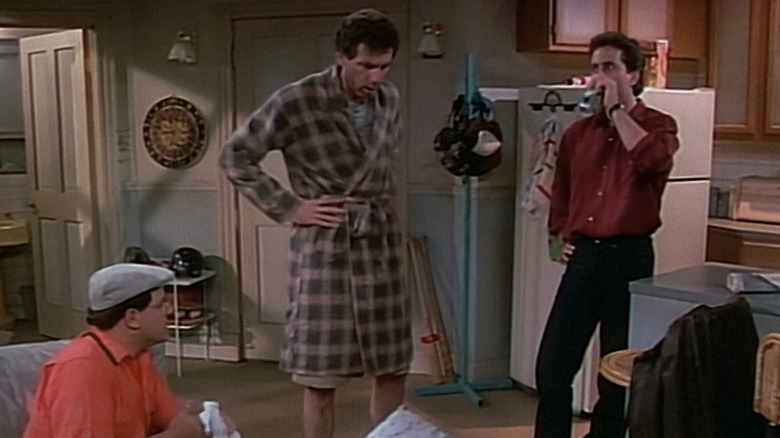 George, Kramer and Jerry standing in a living room in Seinfeld