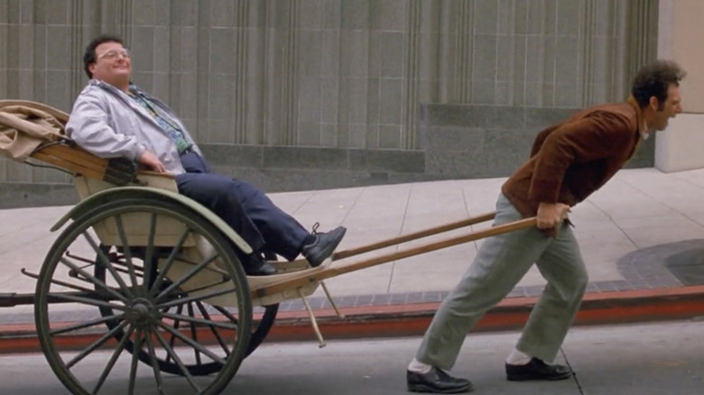 Newman being pulled in a rickshaw by Kramer in Seinfeld