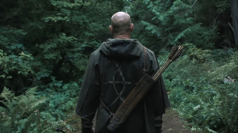 A Seraphite follower is seen wearing cloaked robes with the cult's symbol and carrying  arrows in The Last of Us