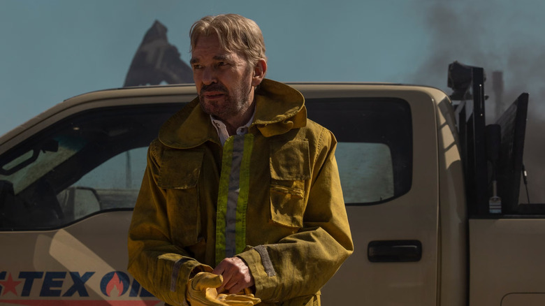 Tommy Norris in a reflective coat outside of a truck on Landman