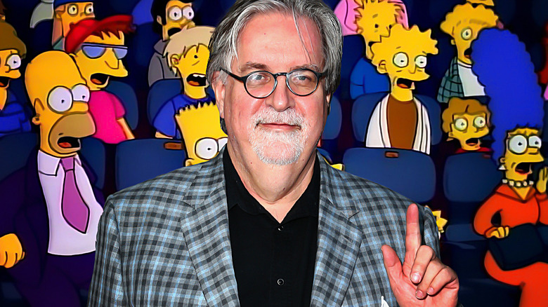 Matt Groening in front of The Simpsons sitting in the movie theater