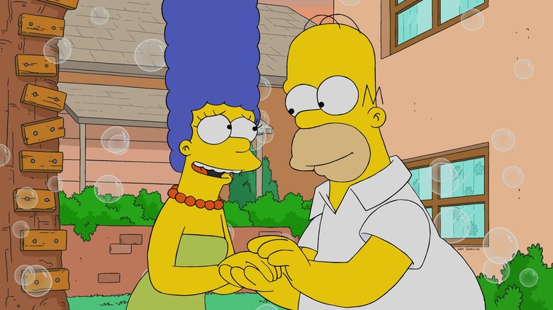 Marge and Homer holding hands in their backyard with bubbles in the background in The Simpsons