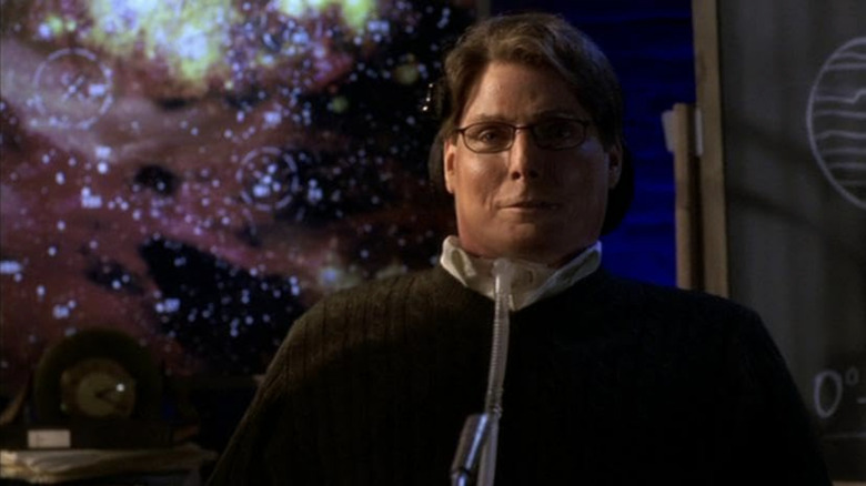Christopher Reeve as Dr Virgil Swann sits behind a desk in Smallville
