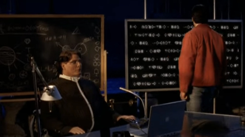 Christopher Reeve as Dr. Virgil Swann sits behind a desk as Tom Welling's Clark Kent stands with his back turned in Smallville