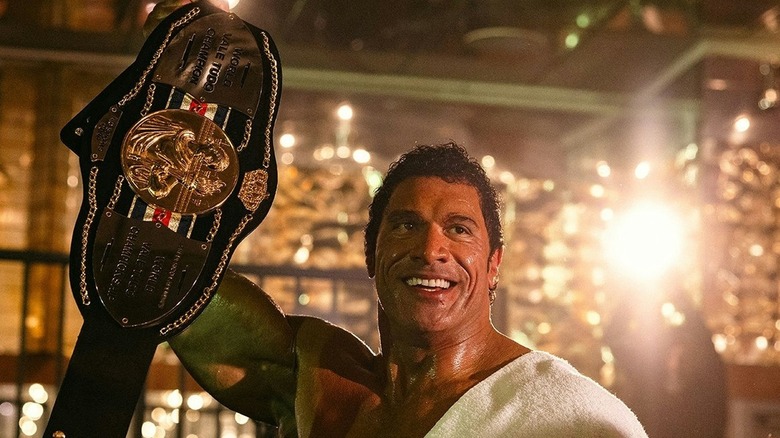 Dwayne Johnson in the role of Mark Care holds the championship belt in a destroying machine