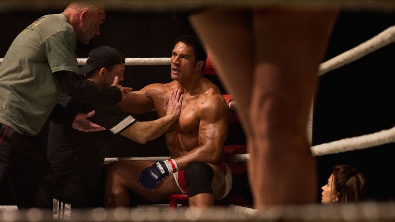 Dwayne Johnson as Mark Kerr sitting by the ropes during a fight in The Smashing Machine
