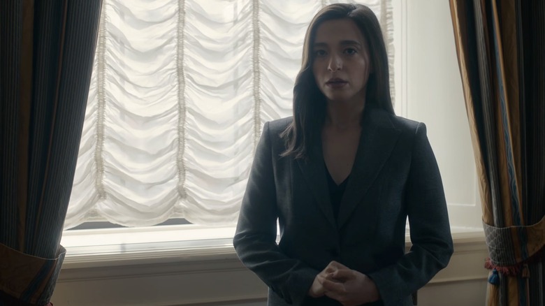 Mikey Madison as Frances Haugen wearing a suit and standing by a window in The Social Reckoning