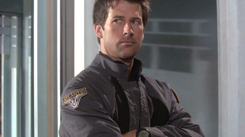Sheppard stands and listens to his team at Stargate Atlantis