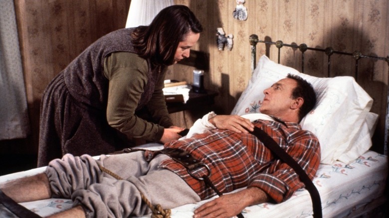 Annie Wilkes tying an injured Paul Sheldon to the bed in Misery
