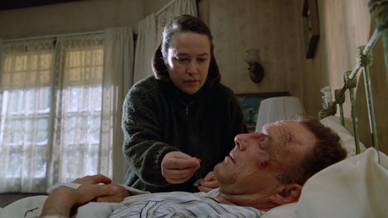 Annie Wilkes giving Paul Sheldon a pill while he's bedridden in Misery
