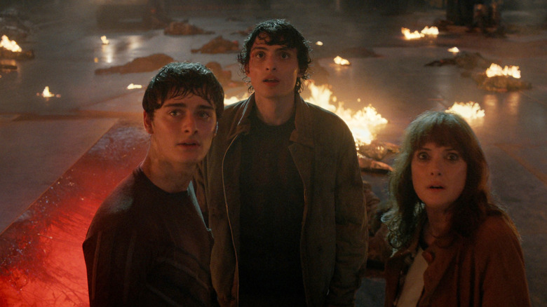Will, Joyce, and Mike staring up amidst flaming wreckage in Stranger Things season 5