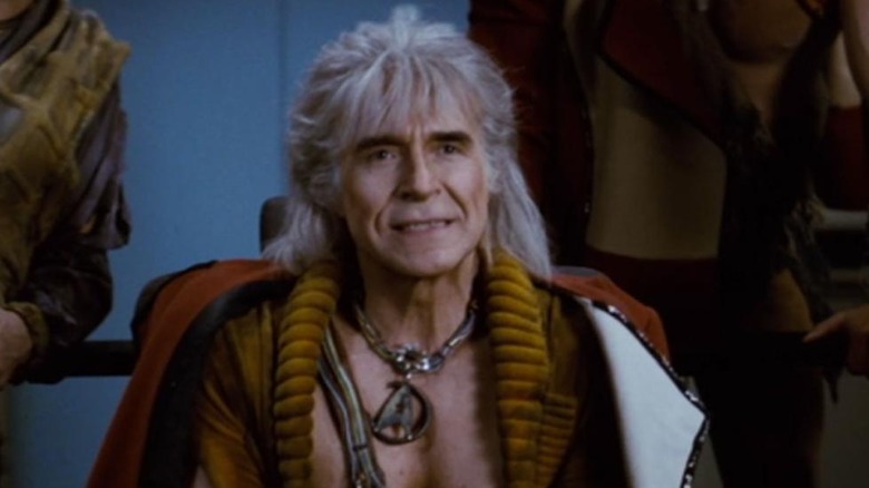 Khan sits stoically