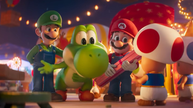 Yoshi stands between Luigi and Mario and bows to Toad in The Super Mario Galaxy Movie