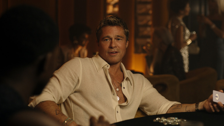 Sonny Hayes glancing sideways at Joshua Pearce as they play poker in F1: The Movie