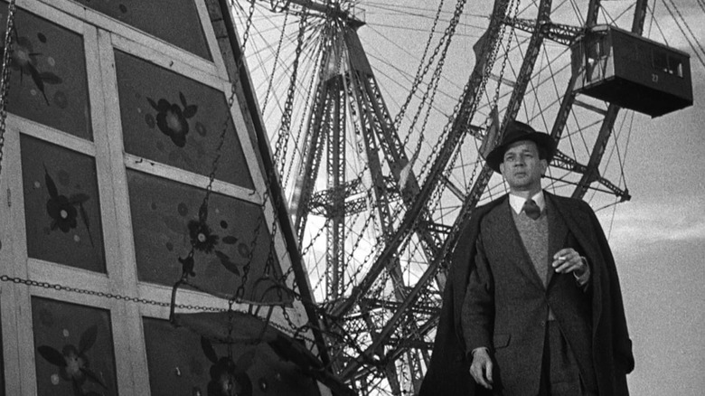 Holly Martins stands in front of the ferris wheel in The Third Man