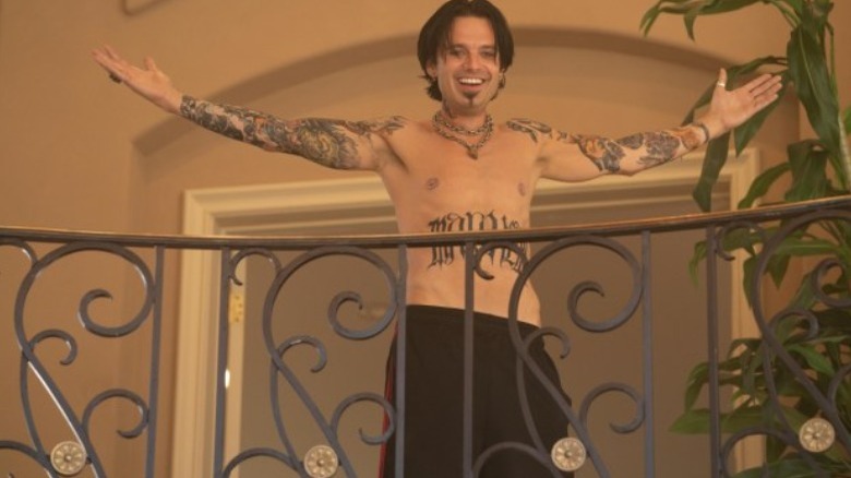 Shirtless Tommy arms up balcony